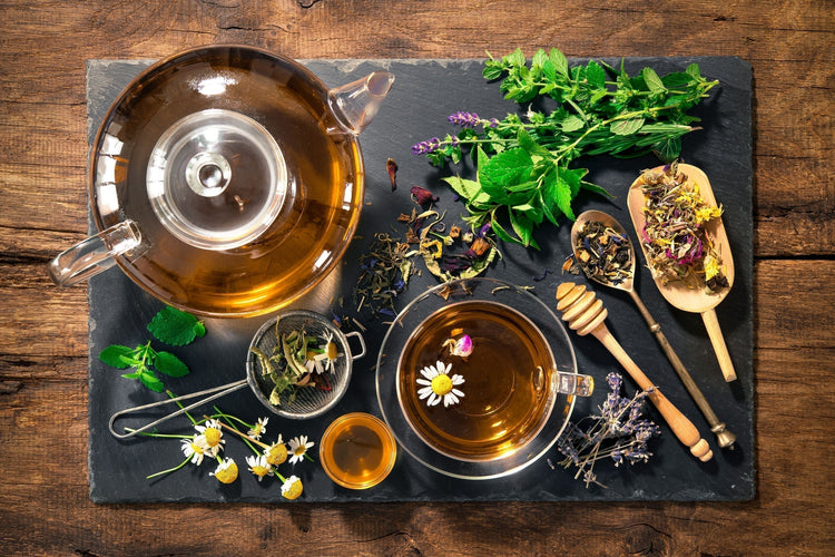 A jar and glass of teas with tea leaves