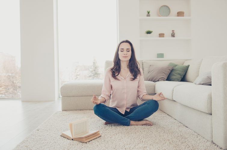 a woman meditating in the living room