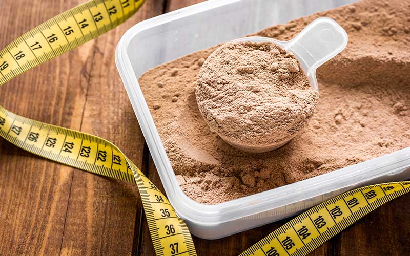 a container and a scoop of scoop of protein powder