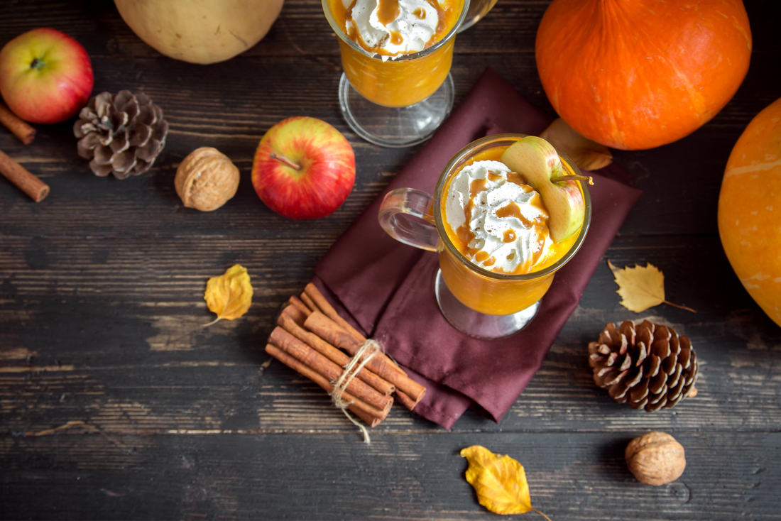 two glasses of smoothie, with fresh apples and cinnamon sticks