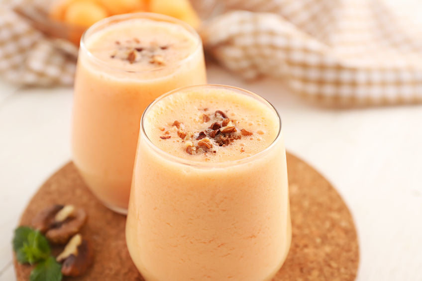 Glasses with tasty fresh melon smoothie on white table, closeup
