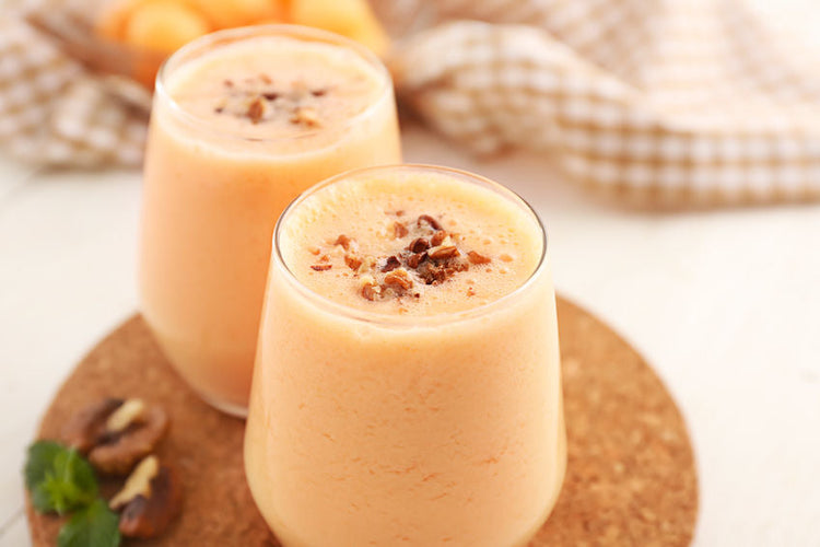 Glasses with tasty fresh melon smoothie on white table, closeup
