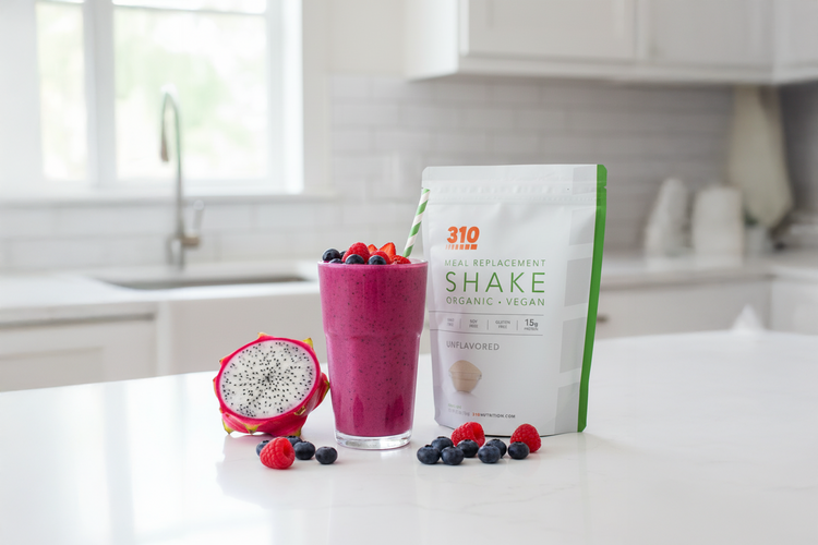 Glass of dragon fruit smoothie with 310 Shake pouch, fresh berries, and sliced dragon fruit.