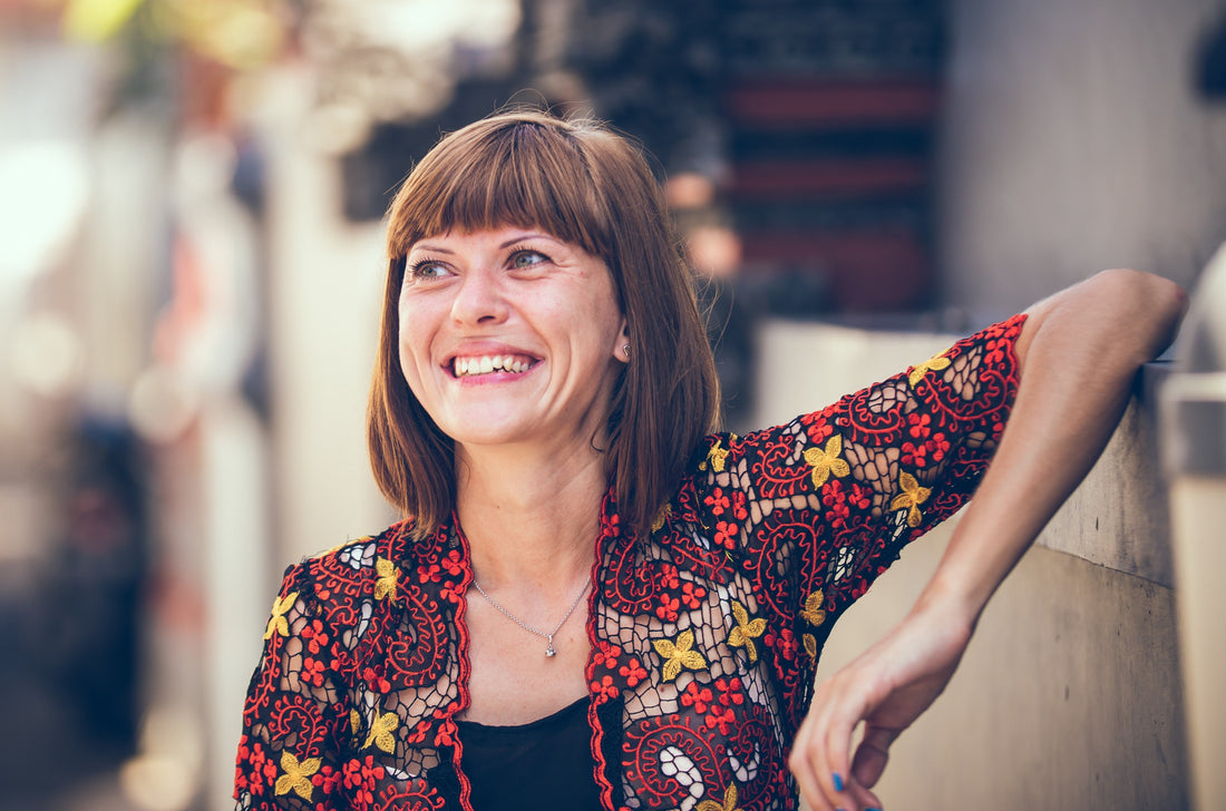 woman smiling while leaning her hand at the counter