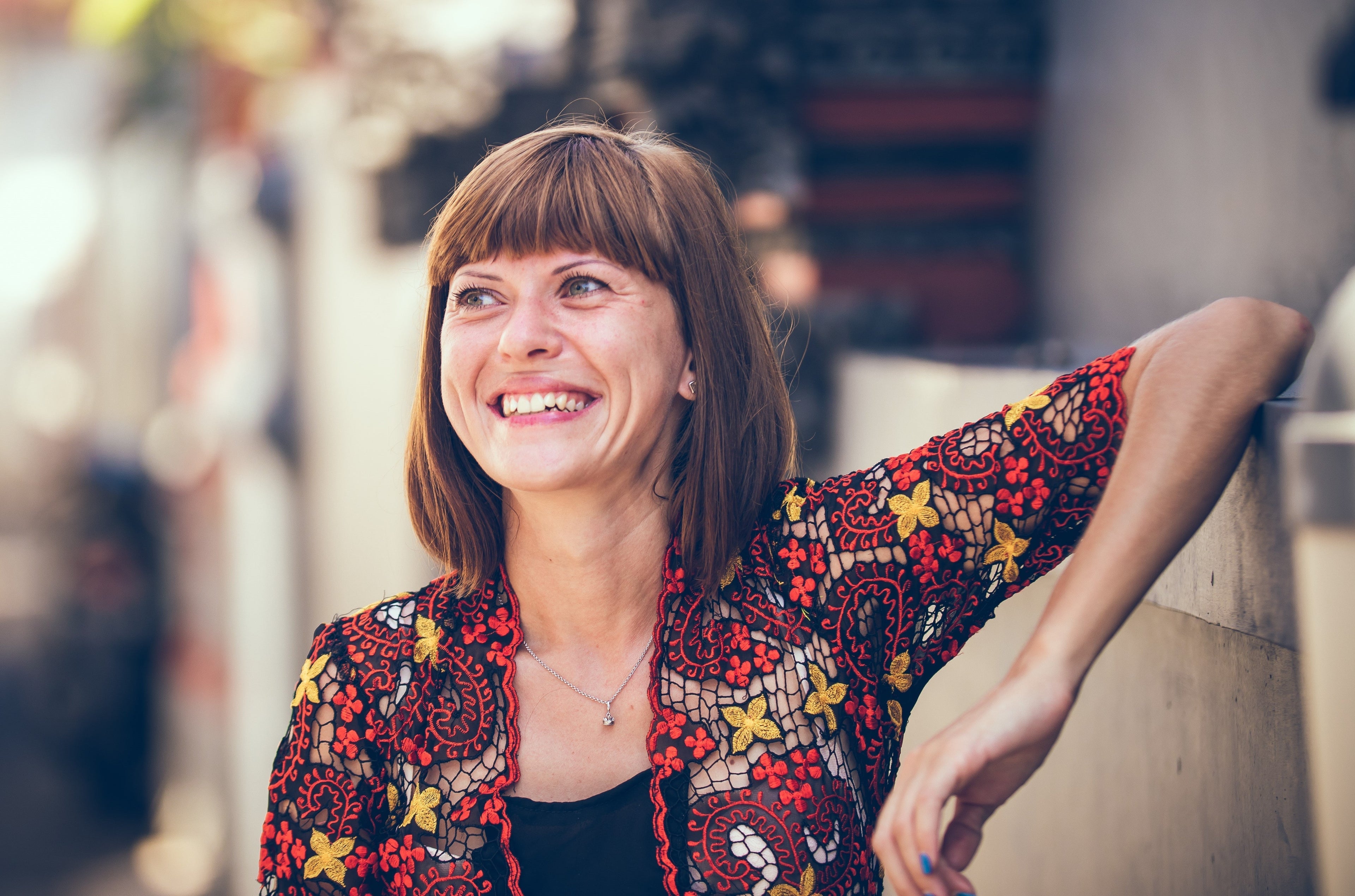 woman smiling while leaning her hand at the counter