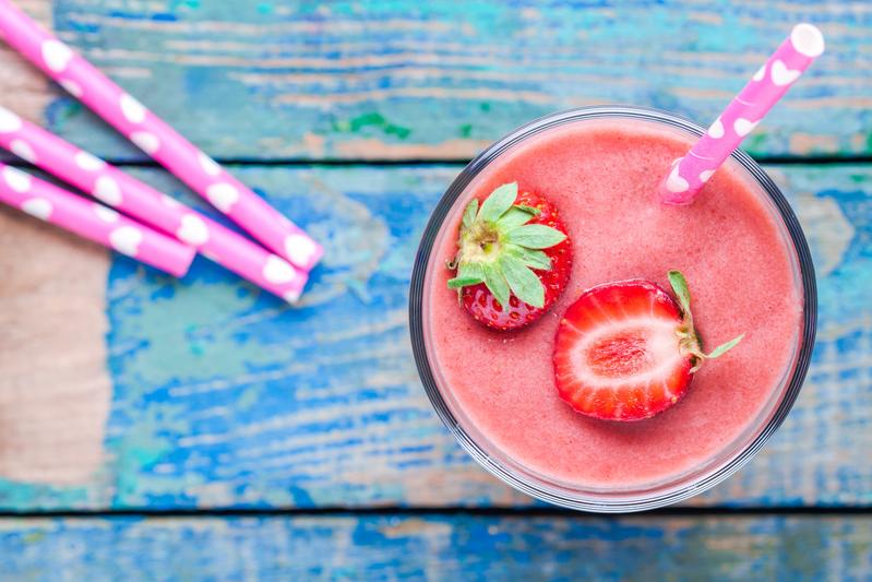 overhead view of strawberry kiwi smoothie garnished with fresh strawberry