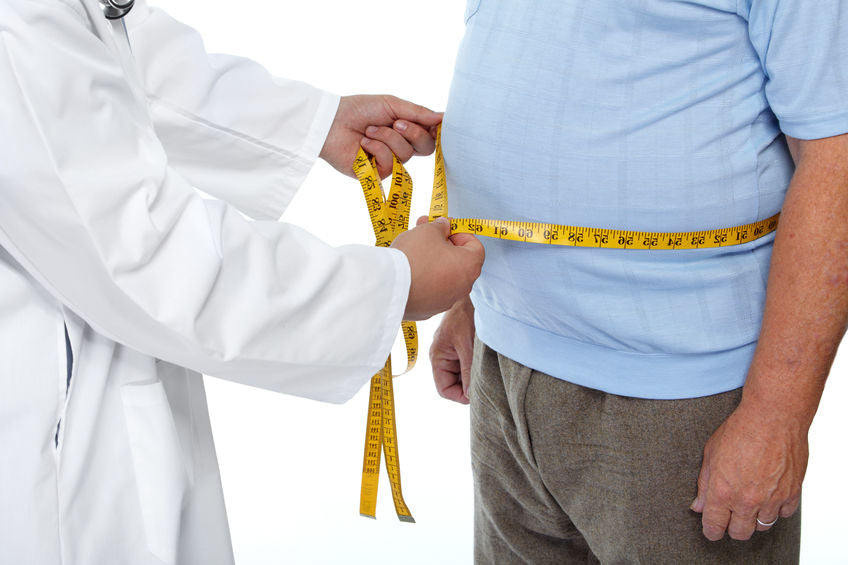 a professional measuring a man's waist with measuring tape