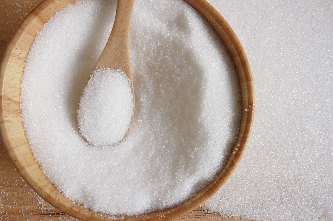 wooden bowl and spoon full of white sugar