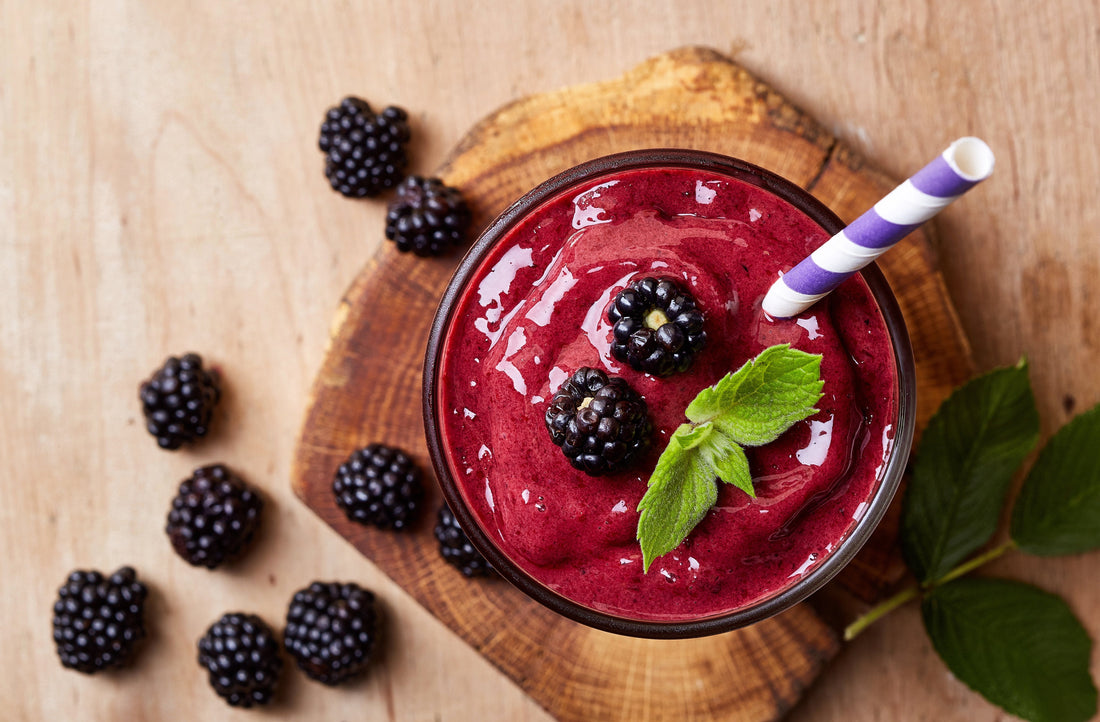 overhead view of a glass of very berry slushee topped with berries and mint leaves