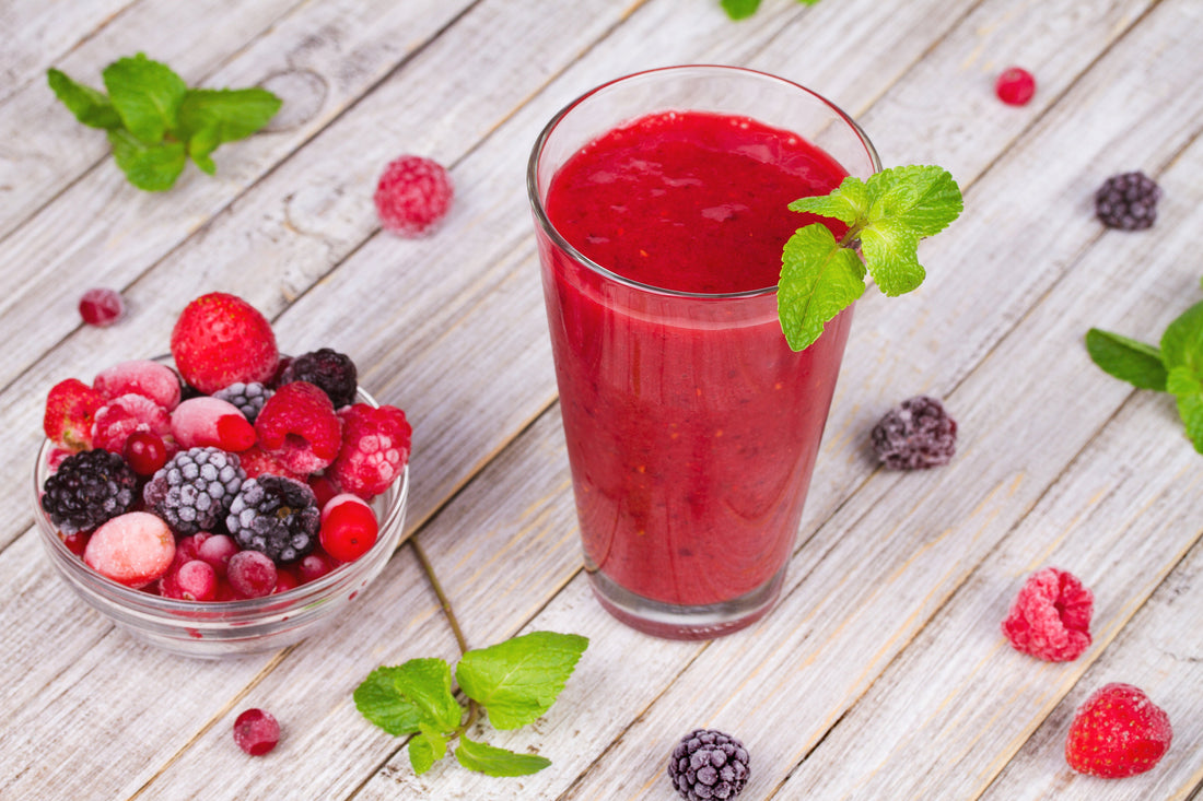 mixed berry smoothie in a glass garnished with mint