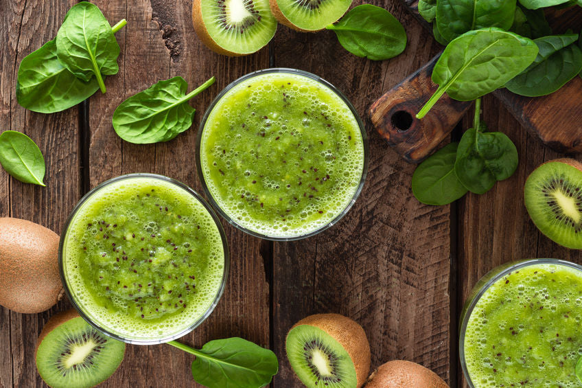 Kiwi smoothie drink of spinach leaves and fresh fruits on wooden rustic table