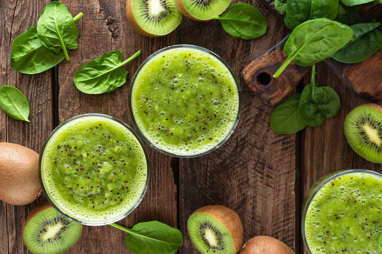Kiwi smoothie drink of spinach leaves and fresh fruits on wooden rustic table