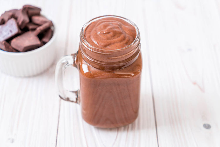 chocolate smoothie in mason jar with bowl of chocolate 
