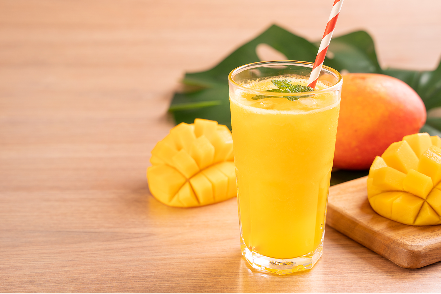 pineapple mango smoothie and a sliced mango 