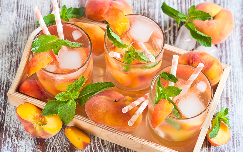 pink peach lemonade with fresh peach and mint leaves