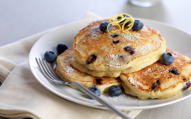 blueberry lemon pancake with fresh blueberries on a white plate