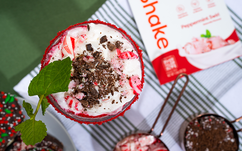 peppermint smoothie with crushed candy cane, protein powder and christmas greenery 