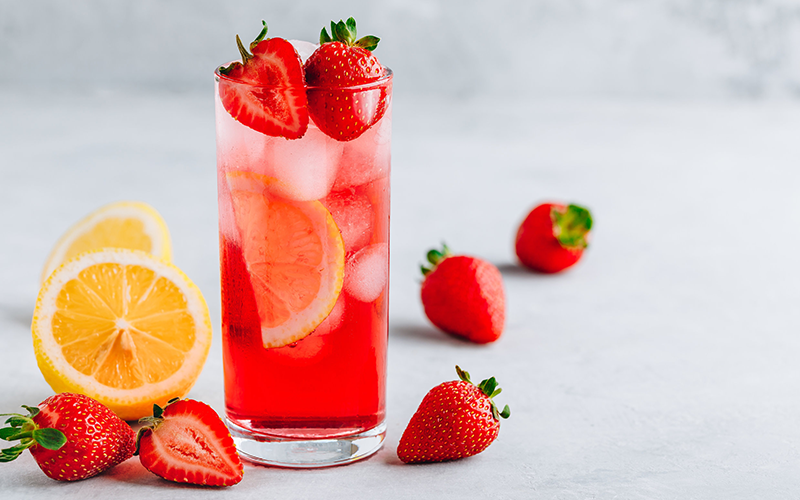 a glass of strawberry lemonade with fresh strawberries