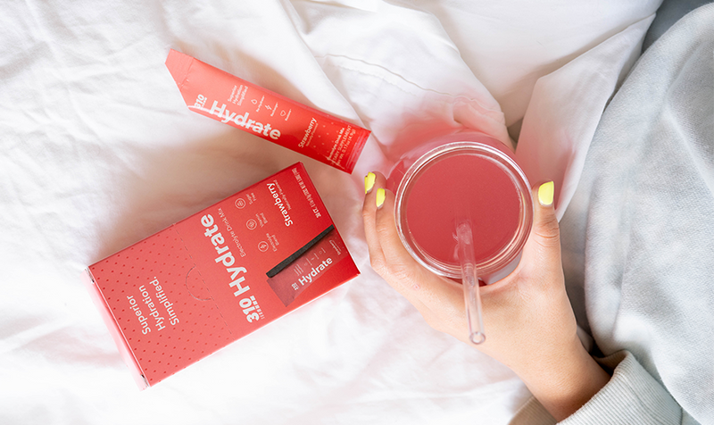 a hand holding a glass of 310 hydrate 