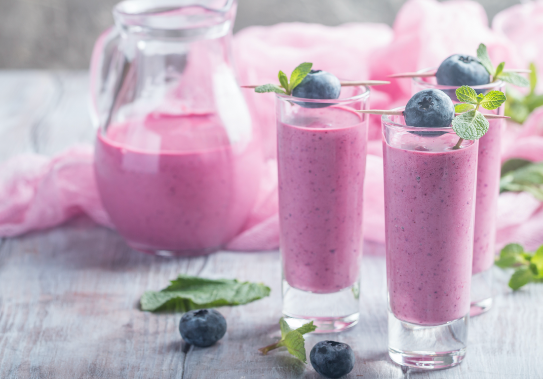 a pitcher and glasses of blueberry shake