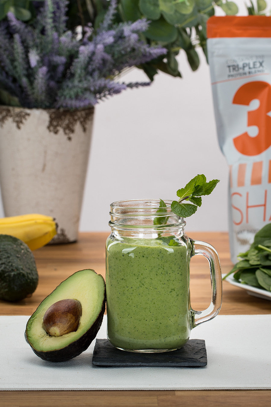 shamrock shake in a mason jar and a sliced avocado