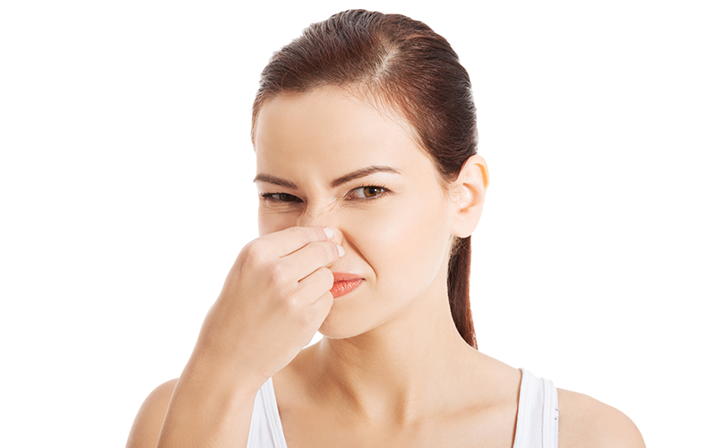 woman pinching her nose due to body odor