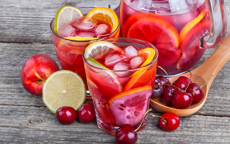 a pitcher and glasses of very berry lemonade on a wooden table