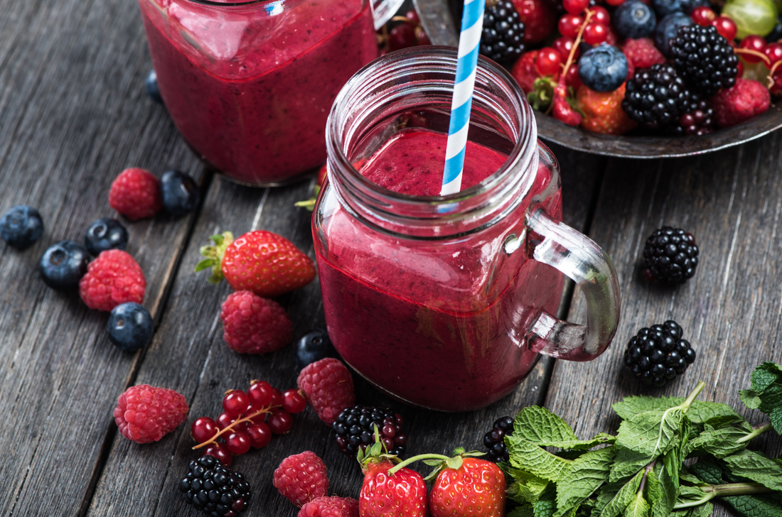 Summer berries smoothie in mason jar on rustic wooden table