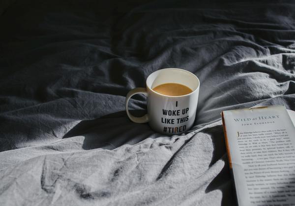 a cup of coffee and book in the bed