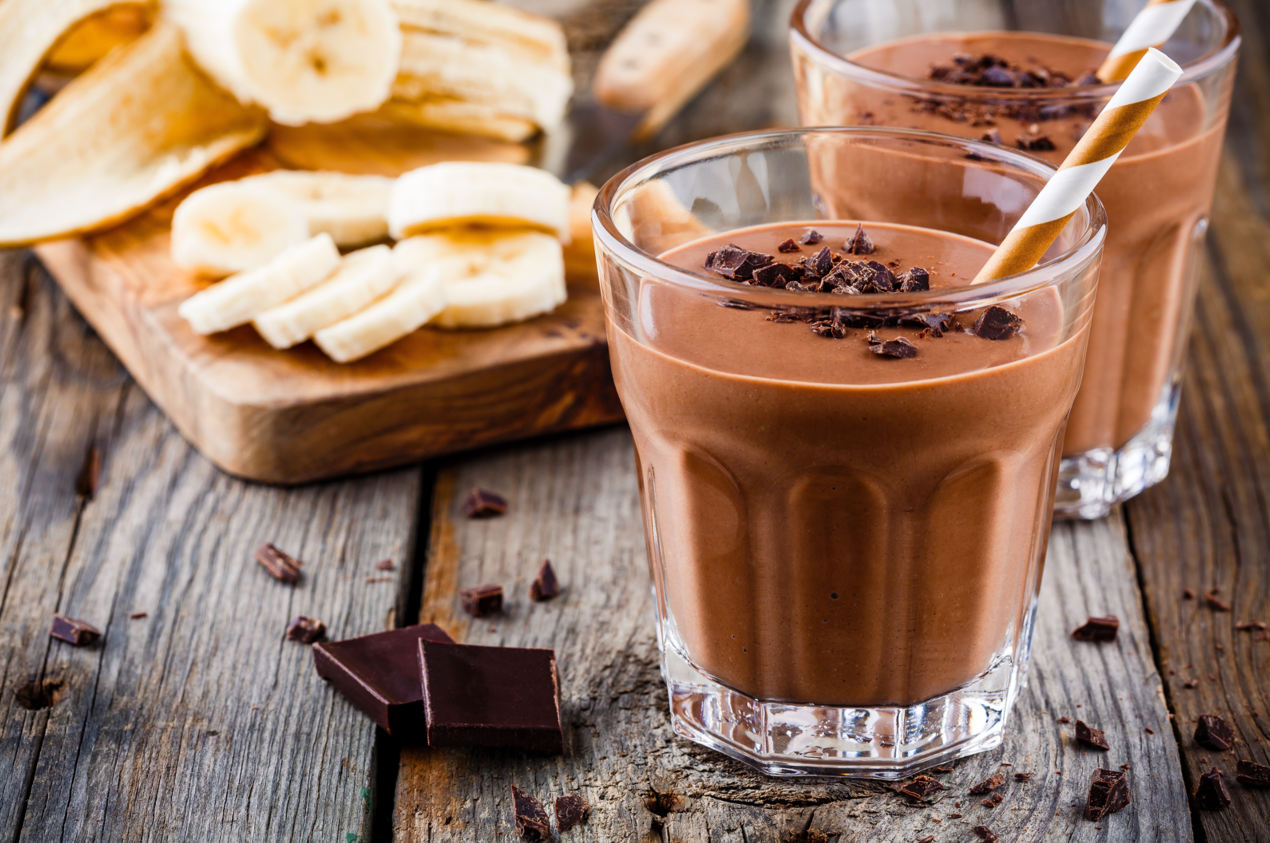 Chocolate smoothie with banana on rustic wooden background