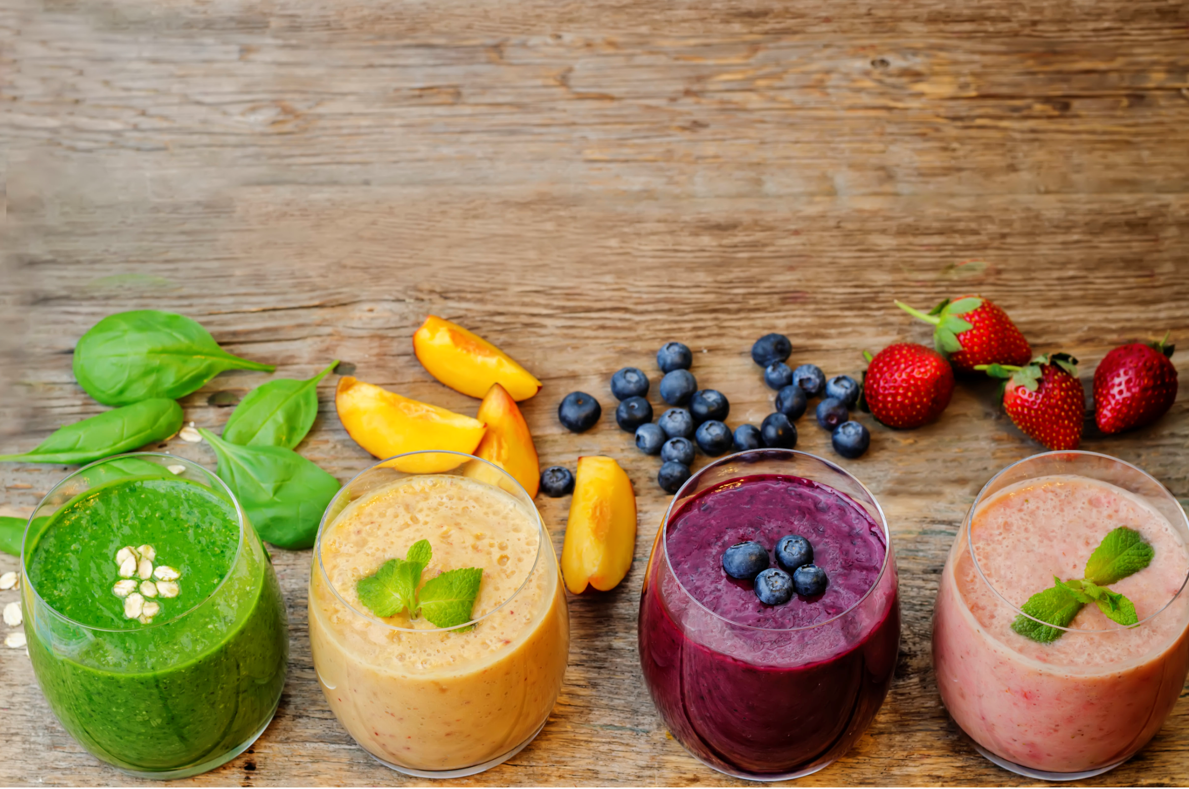 different flavors of smoothies on a wooden table