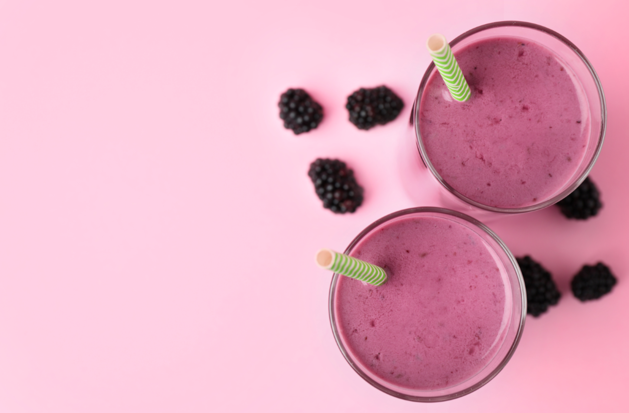 two glasses of blackberry lemon smoothie with green straw