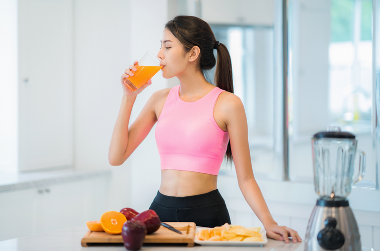 Asian lady in fitness sport wear drink a mix fruit and vegetable for beauty, slim and health after yoga class
