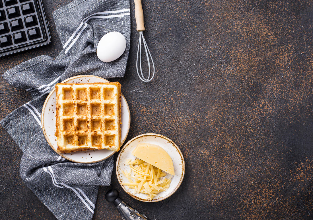 keto waffle with cheese egg and waffle maker on dark background