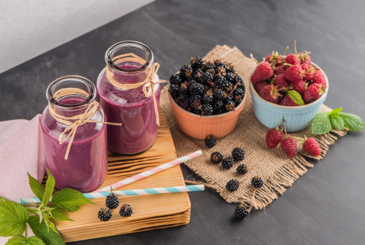 Fresh red fruits smoothie on vintage decorated wooden table