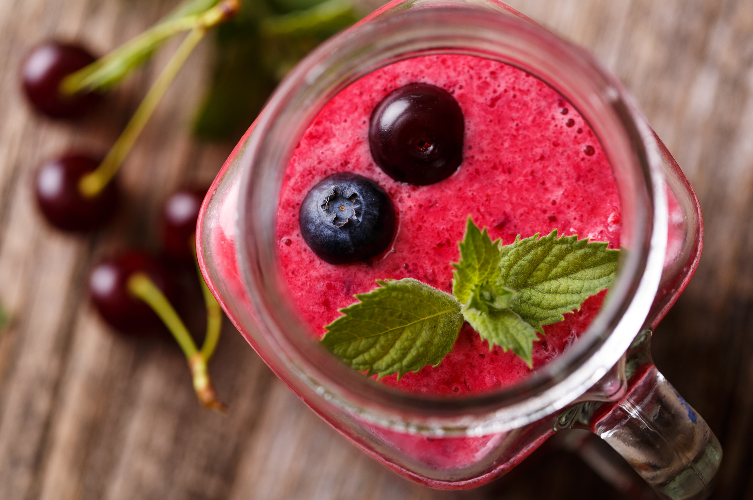 cherry acai smoothie in a mason jar with mint