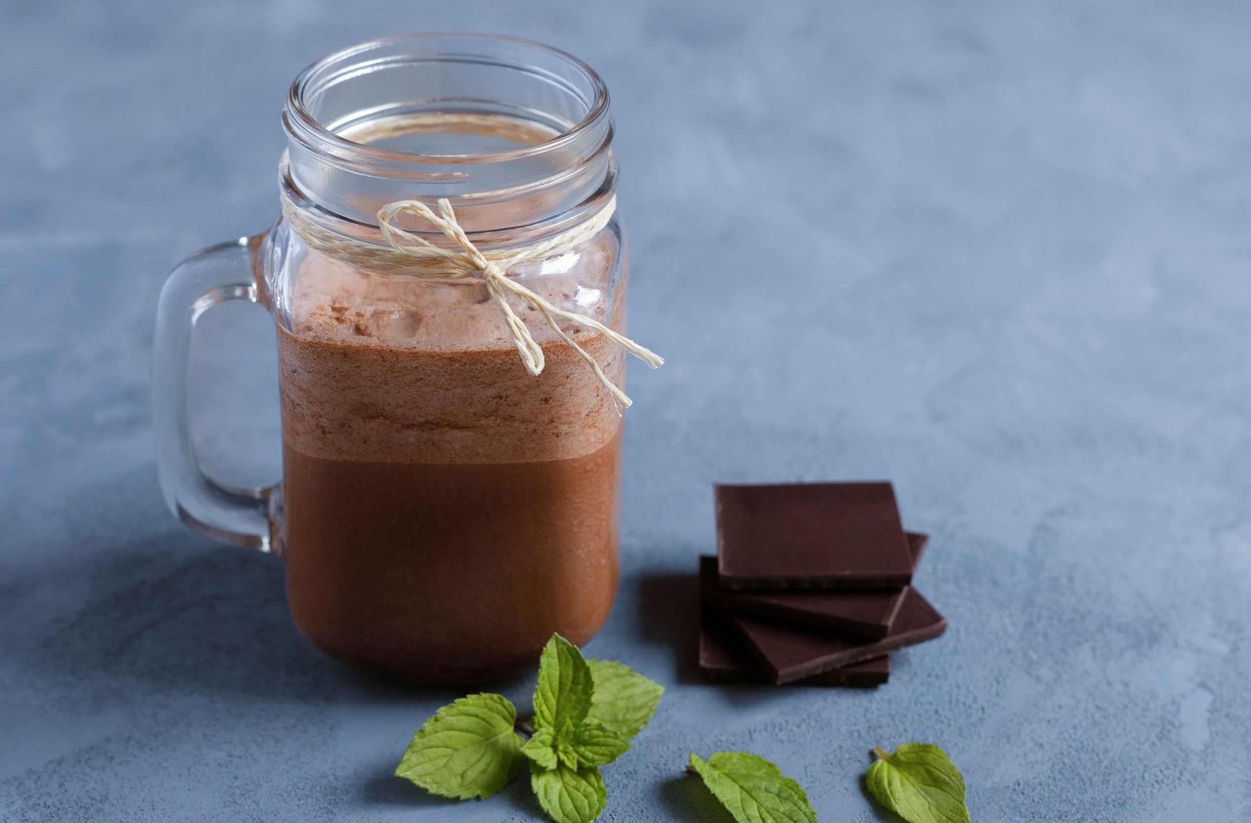 chocolate shake in a mason jar with mint leaves and chocolate chunks