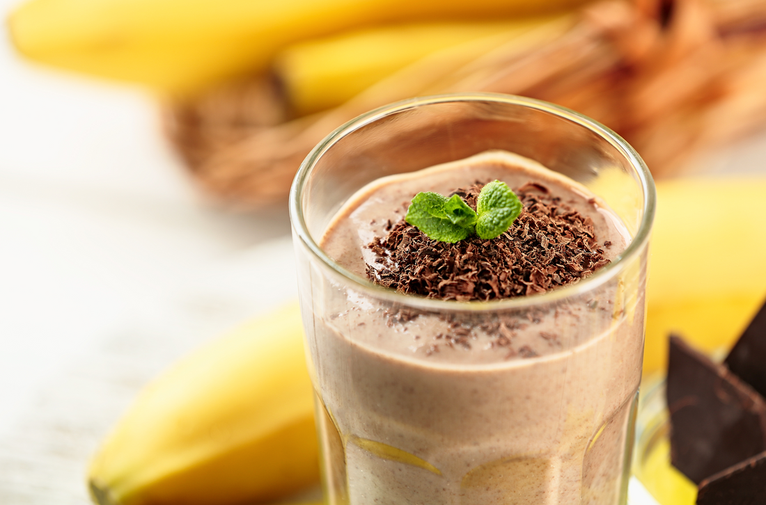 a glass of chocolate peanut butter shake garnished with mint leaves