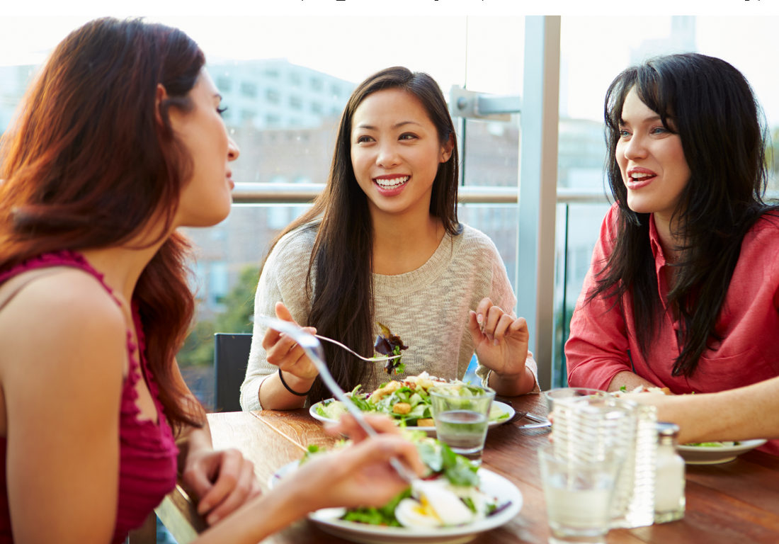 Three Female Friends Enjoying Lunch At Rooftop Restaurant