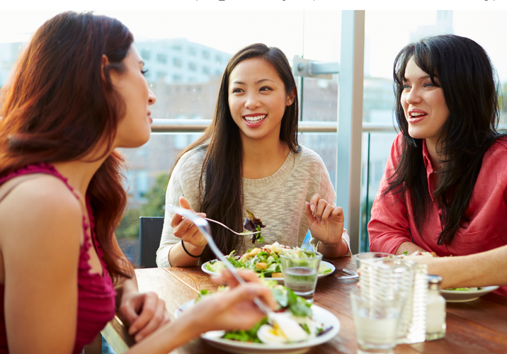 Three Female Friends Enjoying Lunch At Rooftop Restaurant