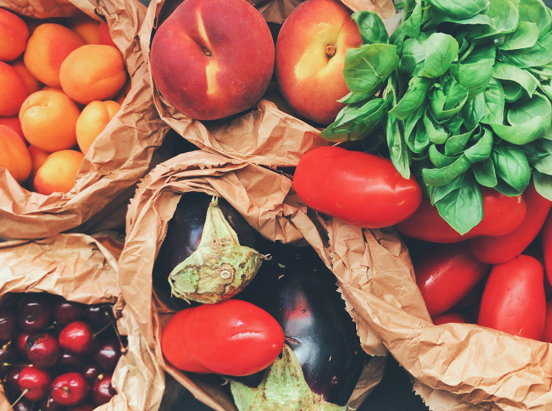 assorted fruits and vegetables in paper bags