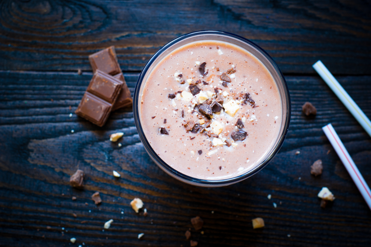 an aerial view of coconut s'mores shake alongside a chunk of chocolates
