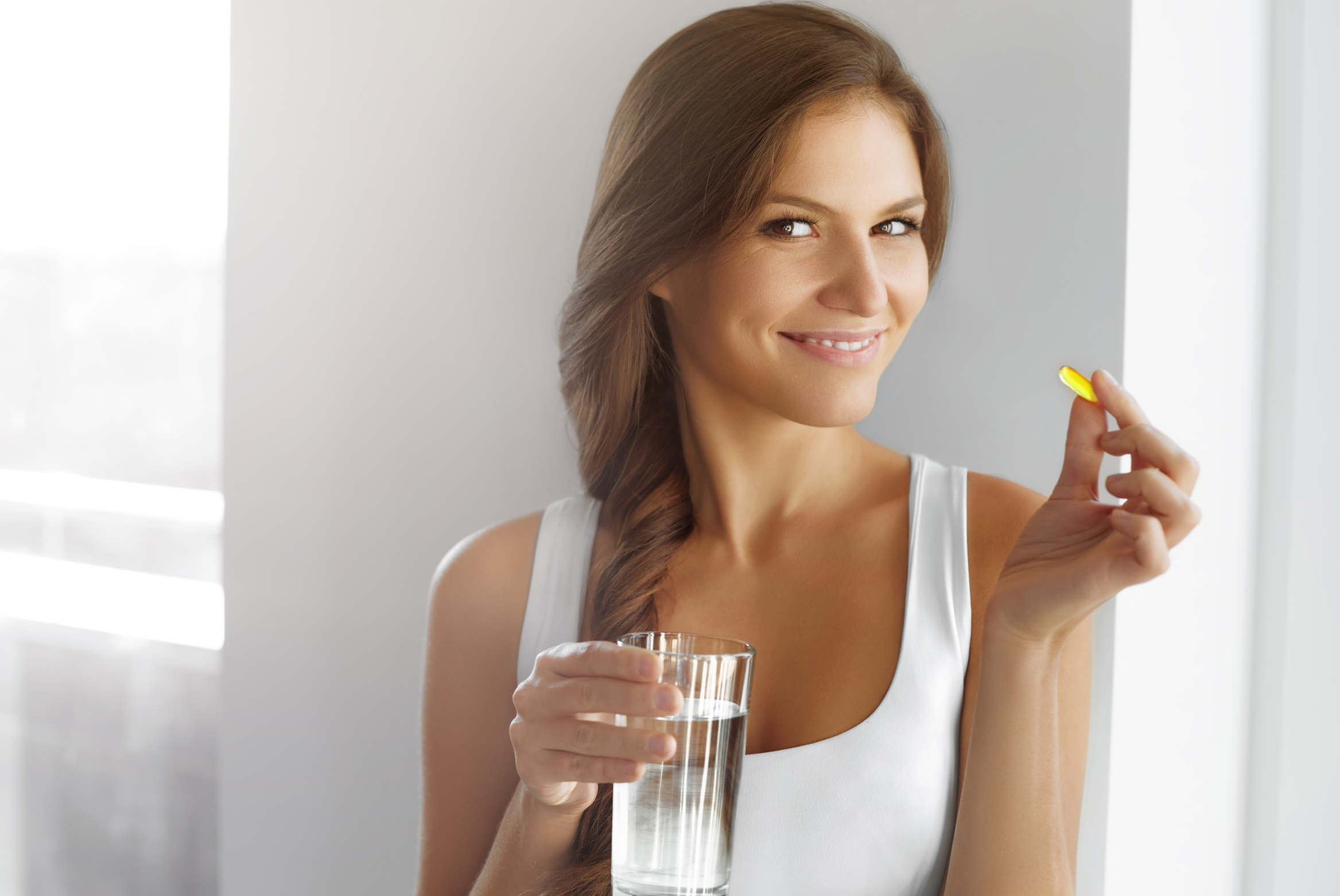 Close Up Of Happy Smiling Woman Taking keto supplement