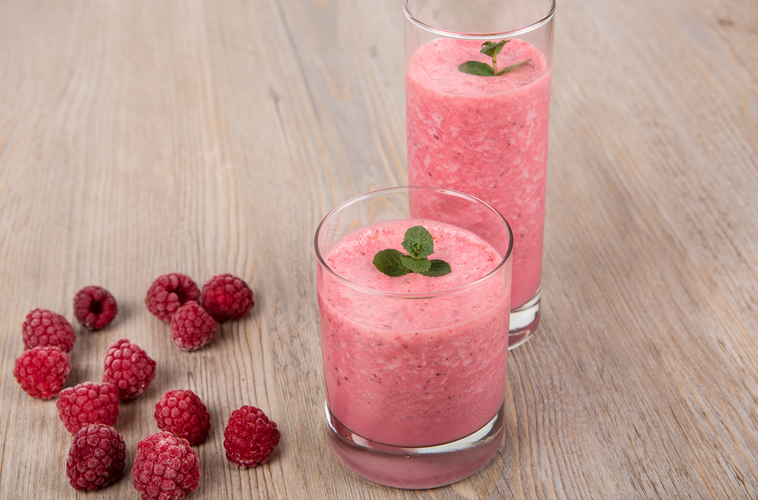 fresh berries and two glasses of smoothie in a wooden surface