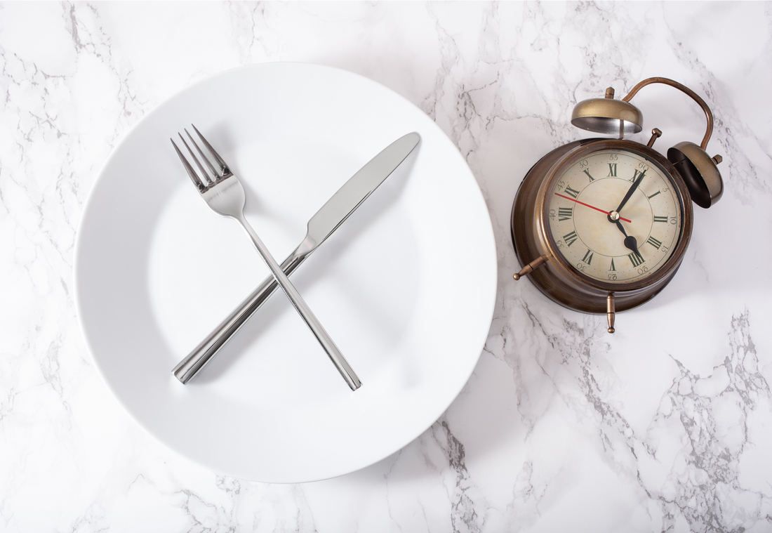 a white plate with knife and fork and clock 