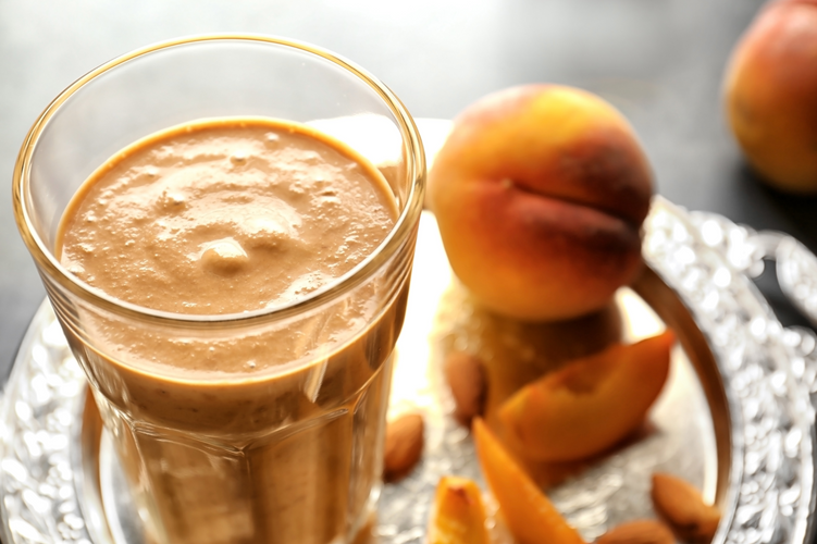 thick and creamy peach smoothie in a glass