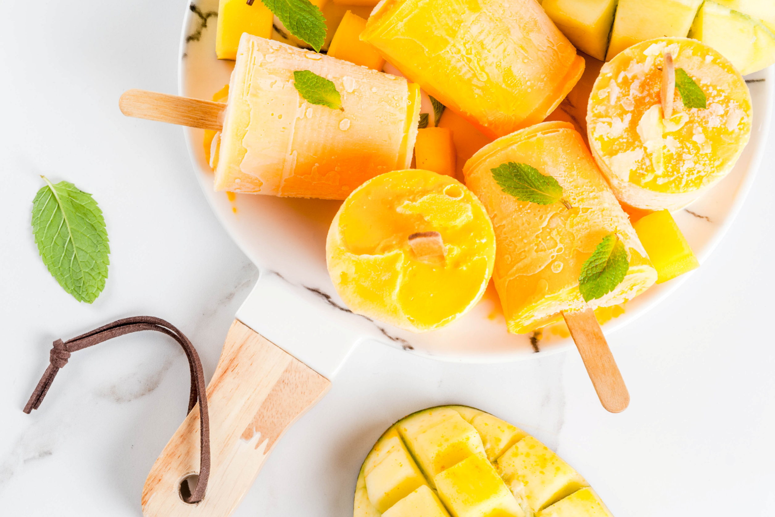a plate full of peach mango hydrate popsicles