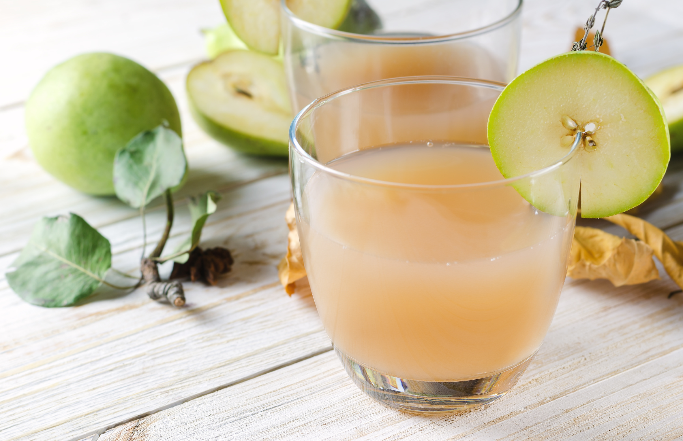 pear smoothie in glass on white wood