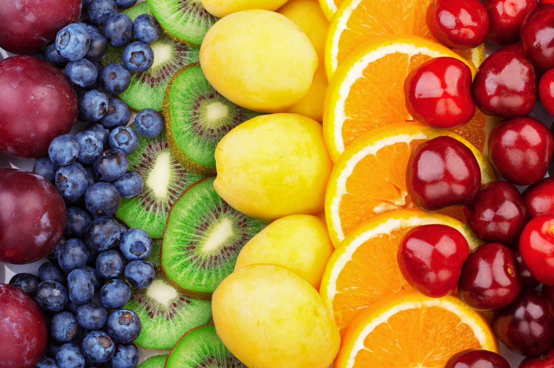 different variety of fresh fruits including berries, kiwi, lemon and orange