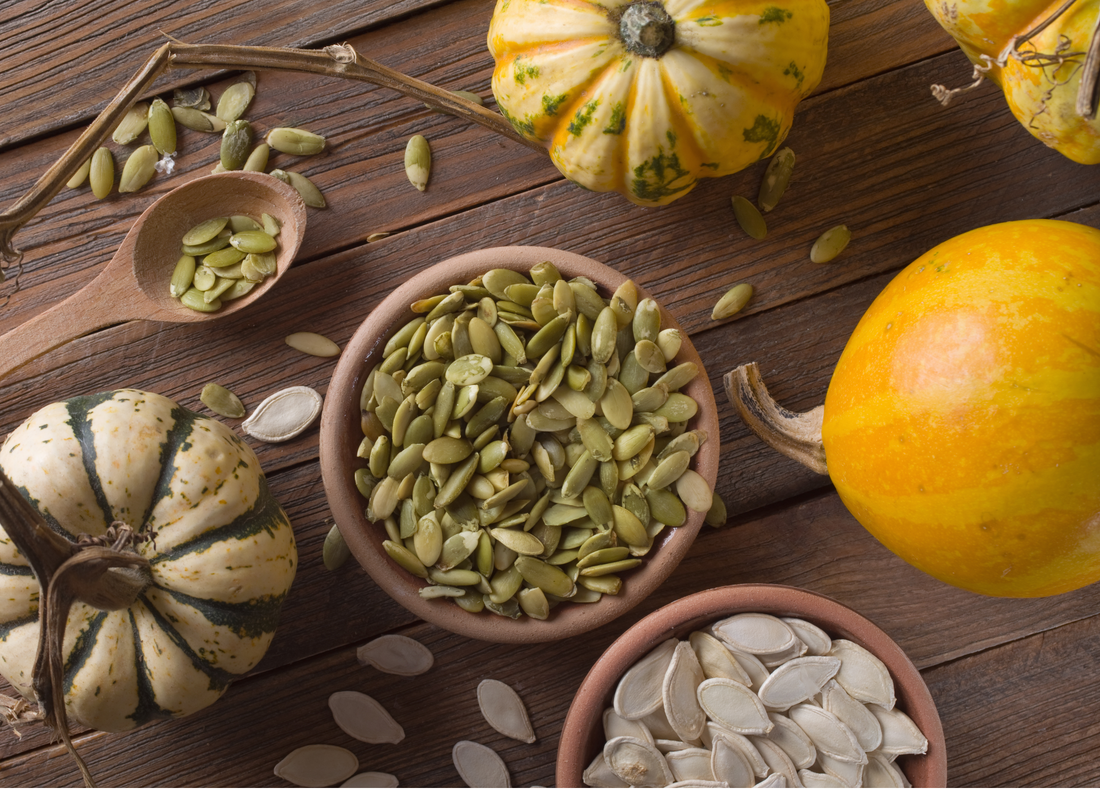 a bowl of pumpkin seeds and a whole pumpkin